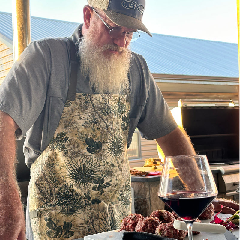 Load image into Gallery viewer, Man wearing gameguard apron standing over meat
