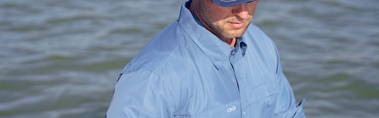 Man standing in water wearing GameGuard MicroFiber Shirt and GameGuard hat