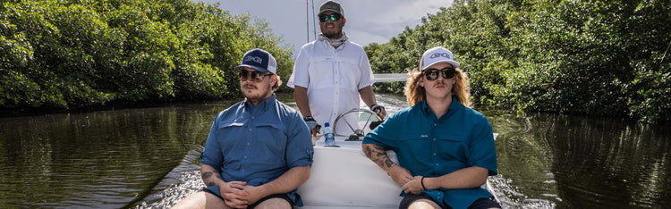 Three men on a boat on the river, all wearing GameGuard shirts and GameGuard hats