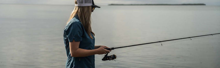 A lady in GameGuard Ladies' Shirt fishing on the sea