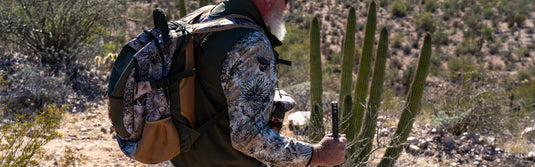 Man hunting walking wearing Guía Grande and a GameGuard backpack and GameGuard bino case