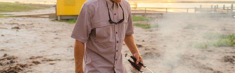 Man grilling on beach wearing GameGuard Maroon TekCheck Shirt