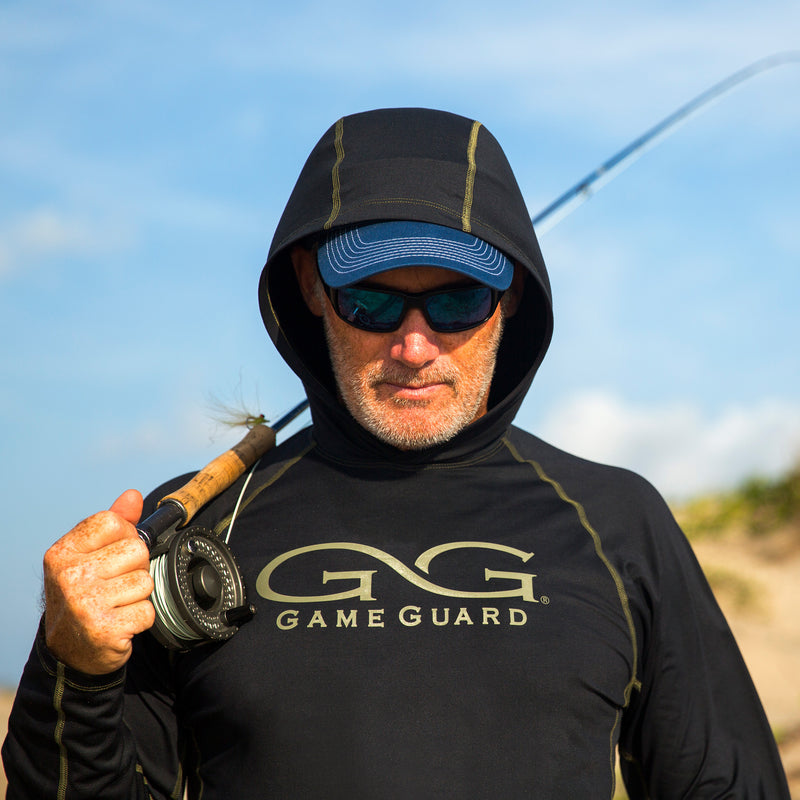Load image into Gallery viewer, Man carrying a fishing pole wearing gameguard performance hoody
