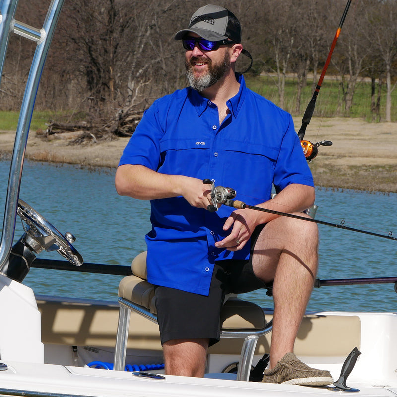 Load image into Gallery viewer, man standing on boat wearing gameguard vaviar shorts, hydroblue microfiber shirt, and gun metal cap with caviar meshback
