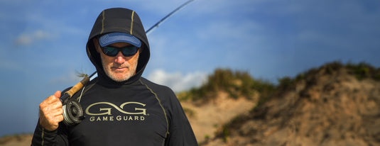 man wearing gameguard caviar performance hoody carrying fishing pole